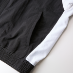 コットンライクなナイロン素材トラックジャケット(ブラック/ホワイト)の裾側面の画像
